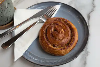 A glazed cinnamon swirl on a grey plate