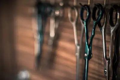 Barber’s scissors hanging on a wooden wall